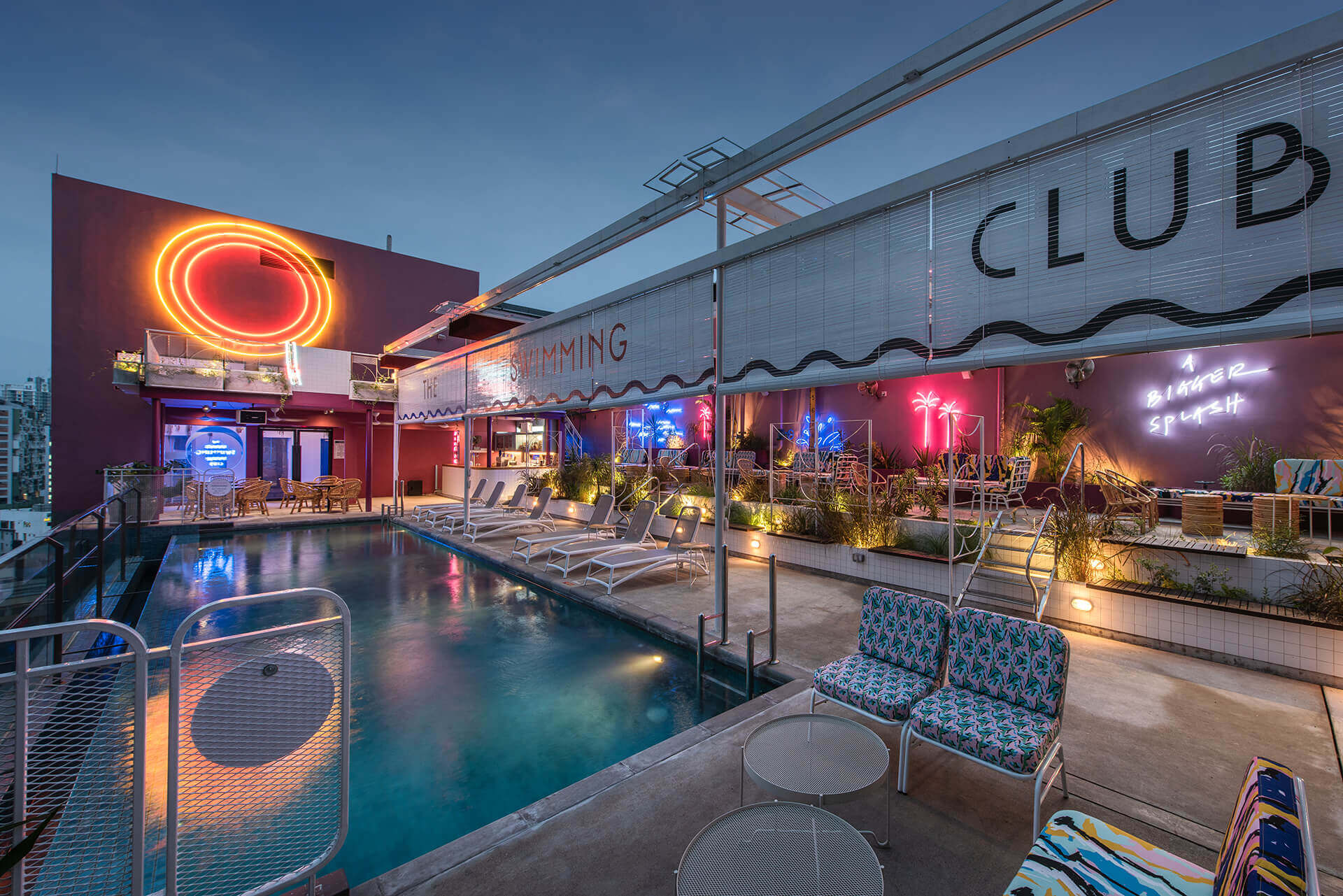 The Swimming Club at night with neon signs at KL Journal Hotel